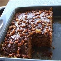 there is a cake in the pan with nuts on it and one slice cut out