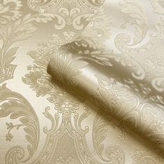 a close up view of a wallpaper with gold and silver designs on the fabric