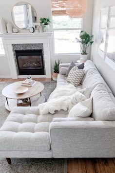 a living room with a couch, coffee table and fire place in the middle of it