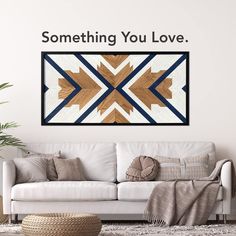 a living room with a white couch and wooden wall art above it that says, something you love