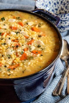 a bowl of soup with carrots, corn and parsley