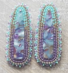 two pairs of beaded earrings on a table