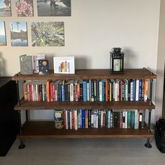 a bookshelf filled with lots of books next to a wall