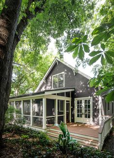 a black and white house surrounded by trees