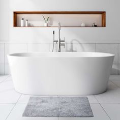 a white bath tub sitting on top of a bathroom floor