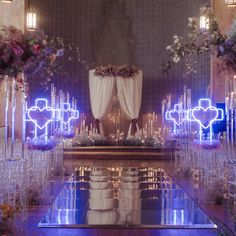 an elaborately decorated wedding venue with candles and flower arrangements on the floor, surrounded by clear glass vases