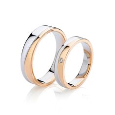 two gold and white wedding rings with diamonds on each side, set against a white background