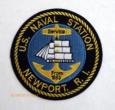 the us naval station newport logo on a black and yellow circular badge with an anchor