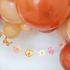 balloons and streamers with peace signs on them are arranged in the shape of flowers