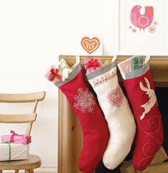 three christmas stockings hanging from a fireplace