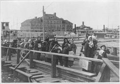 an old black and white photo of people on a bridge