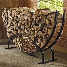 a stack of logs sitting on top of a metal stand next to a brick wall