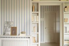 an empty room with bookshelves and a fireplace