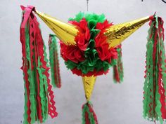 an ornament with red, green and yellow streamers hanging from it's side