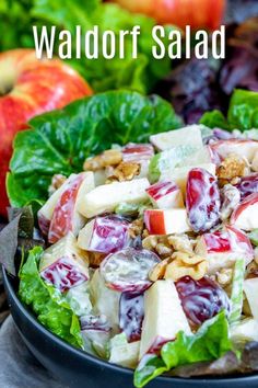 a salad with apples, walnuts and cranberry sauce in a black bowl