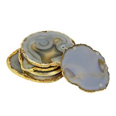 three agate shell coasters stacked on top of each other in gold and grey