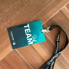 a lanyard that is sitting on the floor next to a tag with team written on it