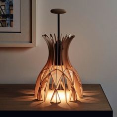 a lamp that is sitting on top of a wooden table next to a framed photo