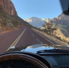 the dashboard of a car on a road with mountains in the background