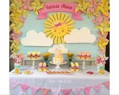 a table topped with cupcakes and cakes covered in frosting next to a wall