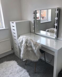 a white desk with a mirror and some drawers