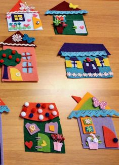 several houses made out of felt sitting on top of a wooden table