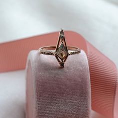 a diamond ring sitting on top of a pink cloth