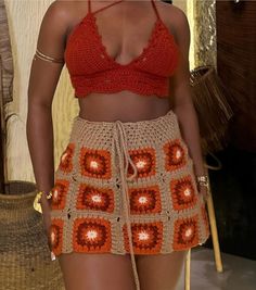 a woman wearing a crocheted skirt and crop top