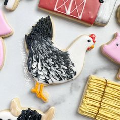 decorated cookies with farm animals and chickens on top of a white tablecloth covered in icing