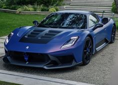 a blue sports car parked in front of some steps