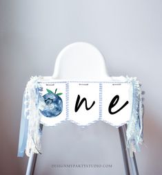 a baby chair with the letters n e and an apple sitting on top of it