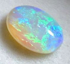 an opal stone sitting on top of a white surface