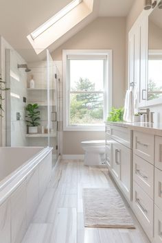 a white bathroom with skylights and large windows above the bathtub is shown in this image