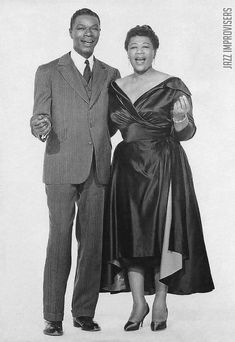 a man and woman standing next to each other in formal wear posing for the camera