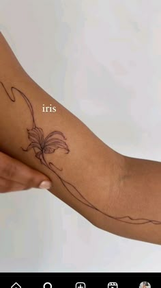 a person with a tattoo on their arm and the words iris written in white ink