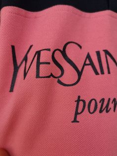 A vintage rare Yves Saint Laurent big logo shirt in pink and dark navy.  Size L.  Slits on the sides It has a marker mark on the neck label probably from the original store (see Pic) .  It looks barely worn, I inspected it and see some reeeally tiny traces of sprinkles in beige on one side. It is so hard to notice though, you have to be very focused to find them. Tried to picture. Otherwise clean and fresh.  All sales are mailed with international registered priority mail service for quick and reliable delivery.  All sales help rescuing of street dog or a cat from the streets of Bulgaria. Thank you! Luxury Red T-shirt With Letter Print, Yves St Laurent T Shirt, T Shirt Yves Saint Laurent, Buy Ysl T Shirt, Yves Saint Laurent Tshirt, Vintage Yves Saint Laurent, Logo Shirt, Neck Label, Pink Top