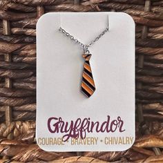 an orange and black striped tie necklace on a card with the words greyfrinder