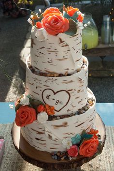 a three tiered cake decorated with flowers and leaves