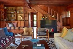 a living room filled with furniture and wooden walls