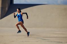 a woman running in a blue shirt and black shorts