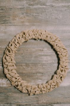 a wreath made out of burlock on a wooden wall with no one around it