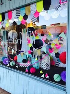 a storefront window decorated with colorful paper decorations