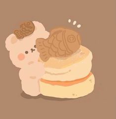 there is a small teddy bear sitting on top of a stack of cakes with frosting