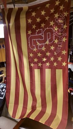 a large red and yellow flag with the number 25 on it hanging from a ceiling