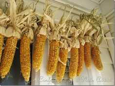 corn on the cob hanging from hooks in front of a door