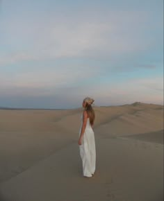 a woman standing in the middle of a desert