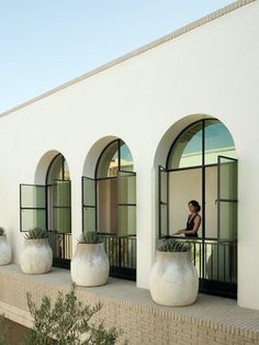 the woman is sitting on the balcony looking out at the building's courtyard area