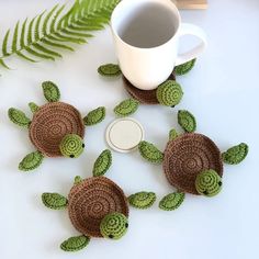 crocheted sea turtle coasters next to a coffee cup on a white table