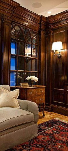 a living room filled with furniture and wooden walls