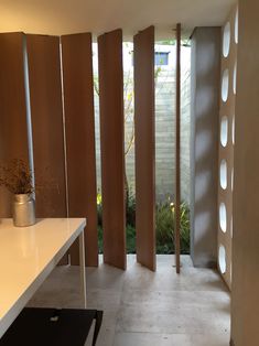 an empty room with white counter tops and wooden partitions on the wall to let in light